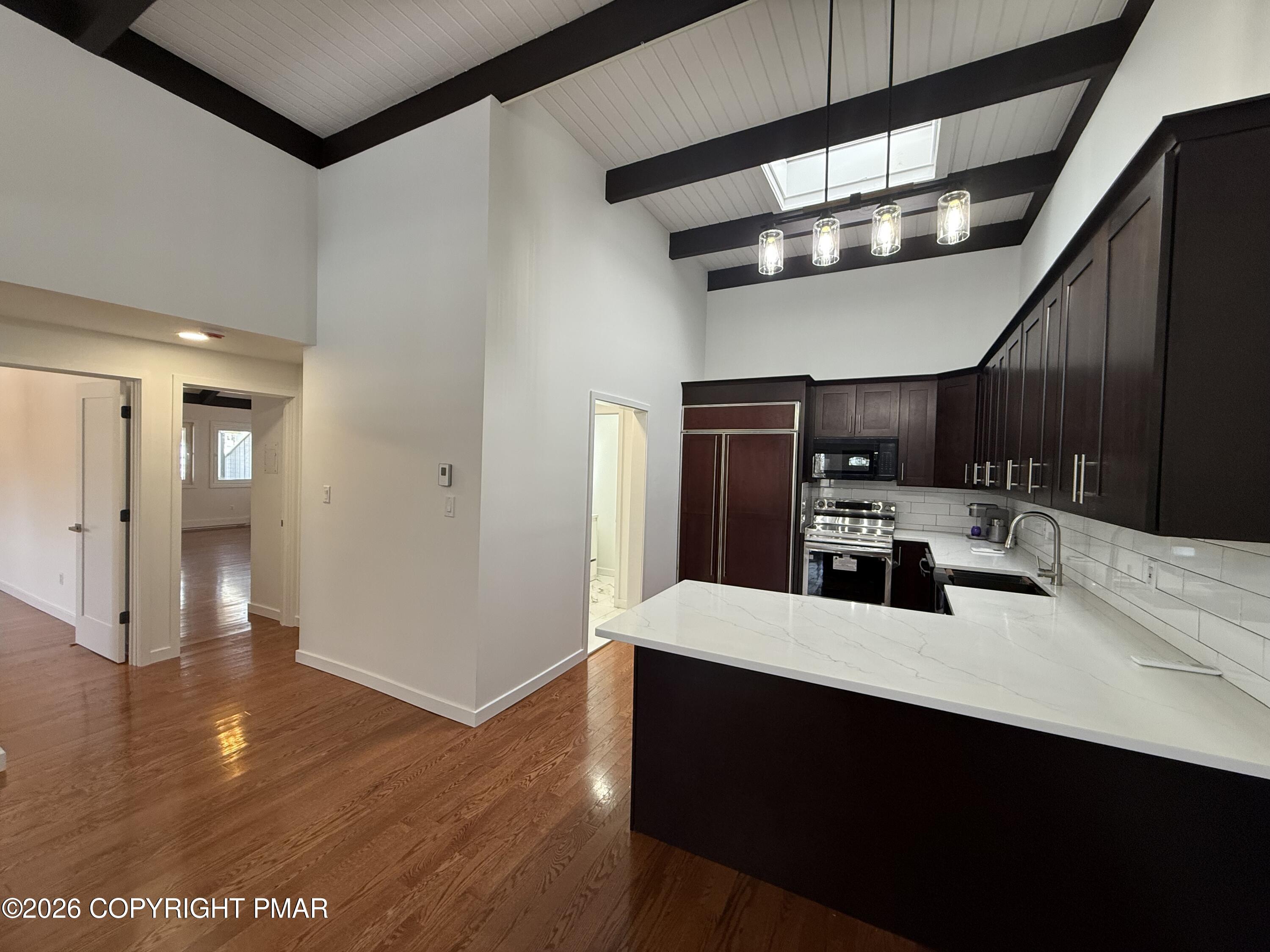 104 Condor Drive, Unit 1 Tamiment, PA 18371 - Photo 8 of 23 a kitchen with stainless steel appliances a sink cabinets and wooden floor