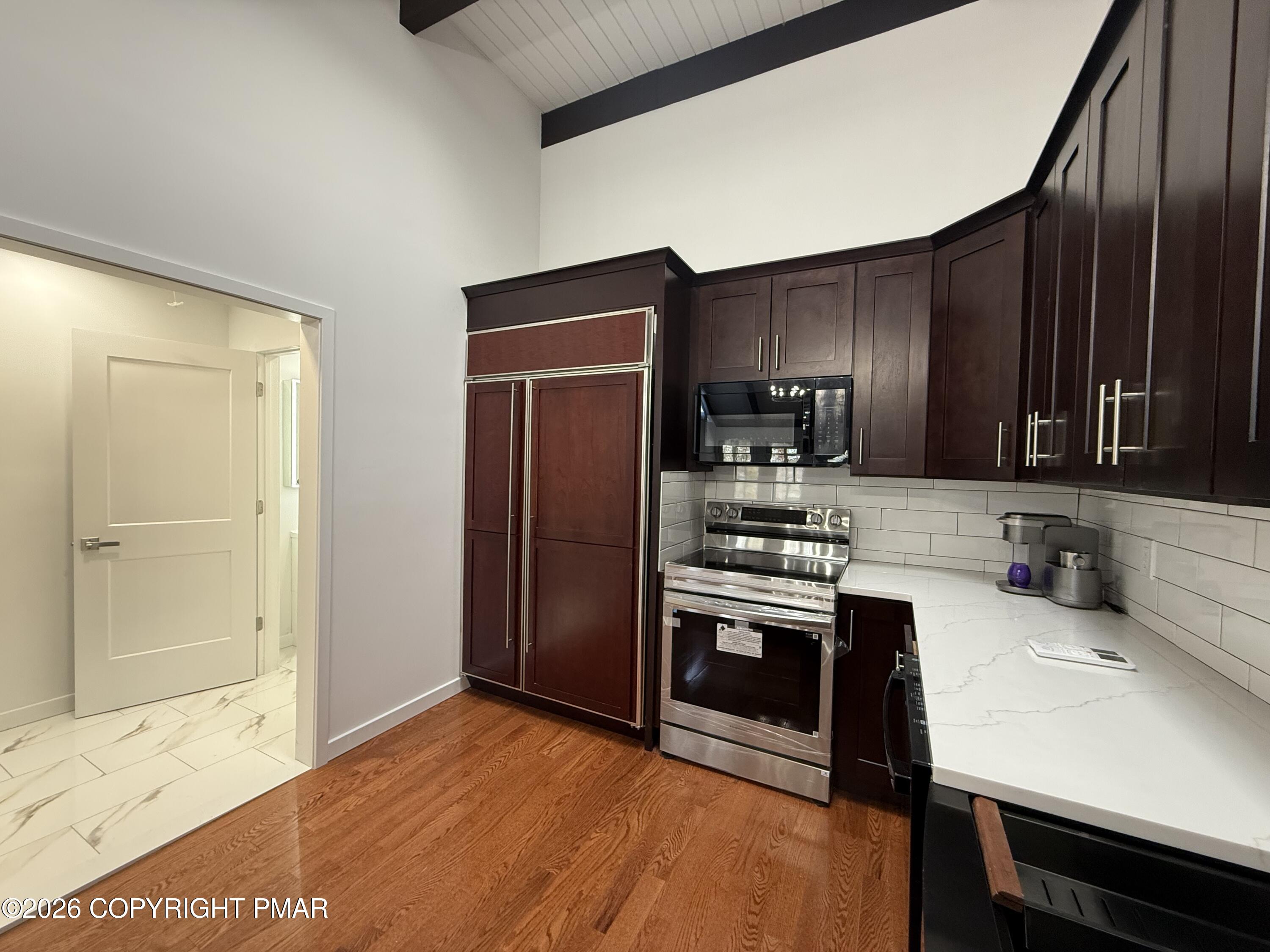 104 Condor Drive, Unit 1 Tamiment, PA 18371 - Photo 10 of 23 a kitchen with stainless steel appliances granite countertop a refrigerator stove and sink