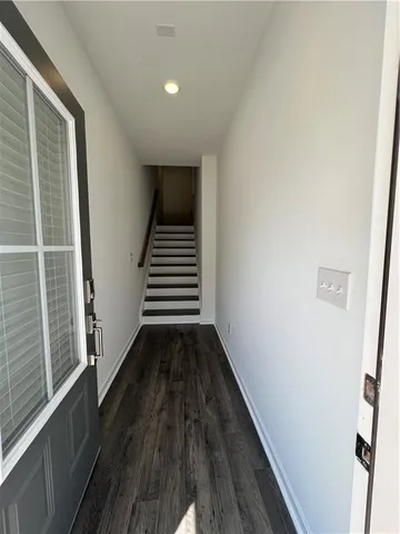 a view of a hallway with wooden floor and staircase