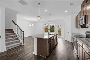 a view of a kitchen with wooden floor and a ceiling fan