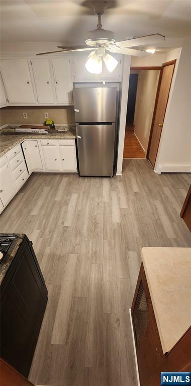 39 Hopper Street, Unit 1 Prospect Park, NJ 07508 - Photo 3 of 7 a kitchen with a wooden floor and cabinets