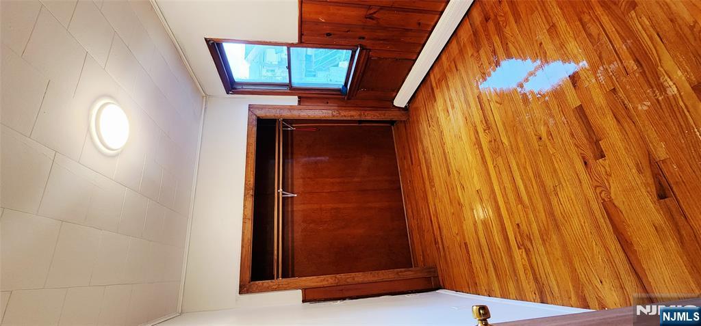 39 Hopper Street, Unit 1 Prospect Park, NJ 07508 - Photo 5 of 7 a view of an empty room with wooden floor and a window