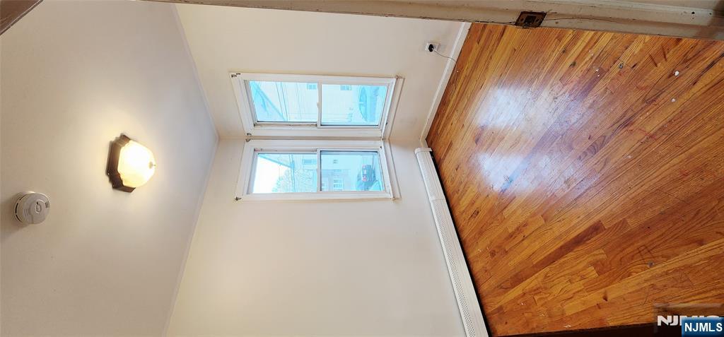 39 Hopper Street, Unit 1 Prospect Park, NJ 07508 - Photo 6 of 7 an empty room with wooden floor and windows