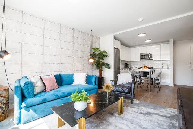 a living room with furniture kitchen view and a potted plant