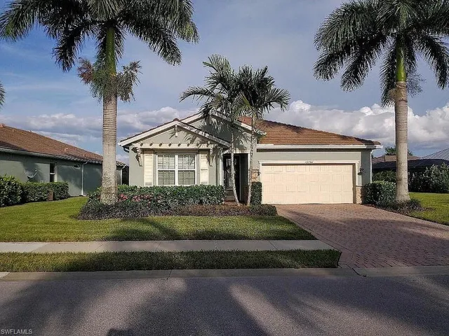 a front view of a house with garden and garage