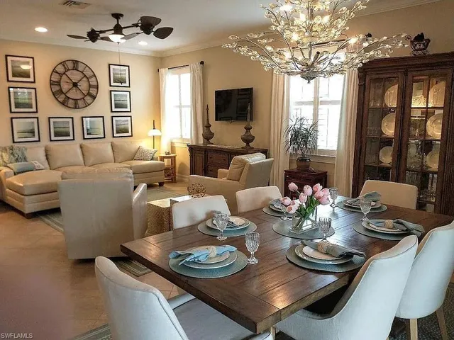a living room with furniture a chandelier and a large mirror