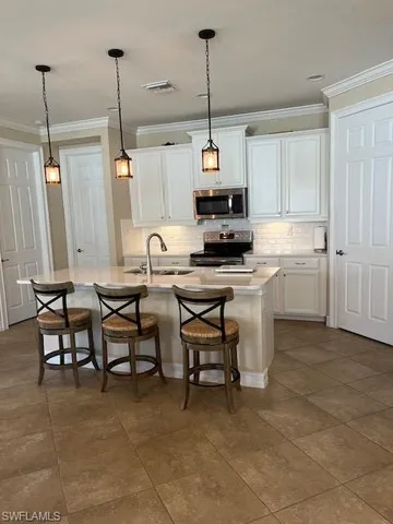 a kitchen with kitchen island a dining table chairs sink and cabinets