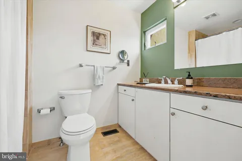 a bathroom with a toilet a sink and mirror