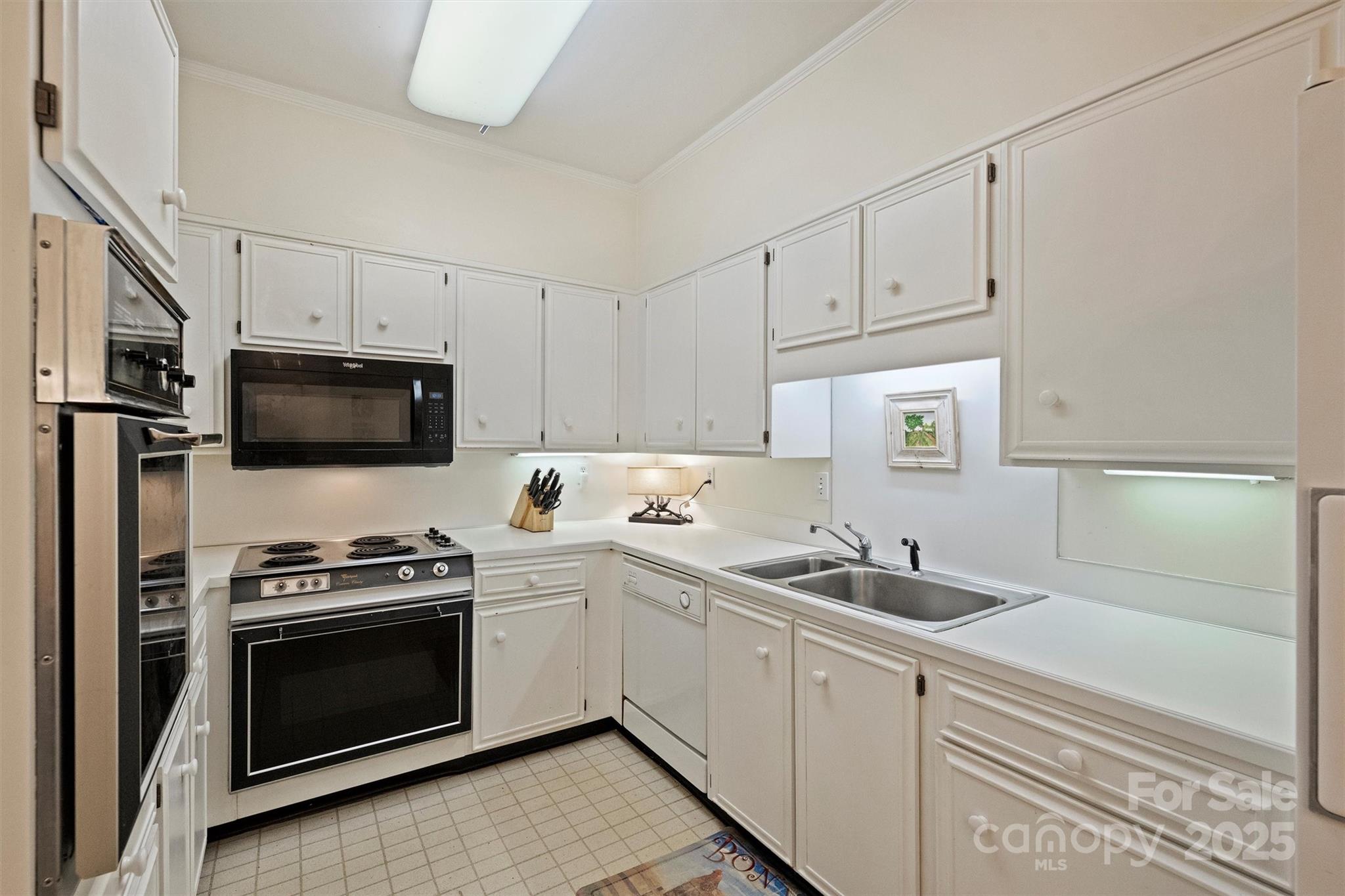 904 Cherokee Road Charlotte, NC 28207 - Photo 18 of 36 a kitchen with white cabinets stainless steel appliances and sink