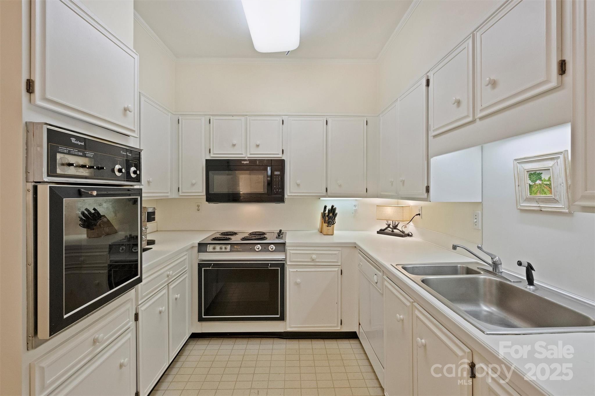 904 Cherokee Road Charlotte, NC 28207 - Photo 4 of 36 a kitchen with white cabinets sink and stainless steel appliances