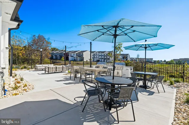 a view of a patio with a dining table and chairs under an umbrella