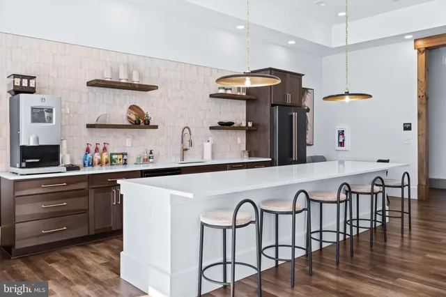 a kitchen with stainless steel appliances granite countertop a sink and a refrigerator