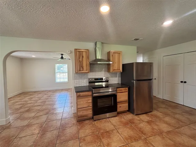 a kitchen with stainless steel appliances granite countertop a stove top oven and refrigerator
