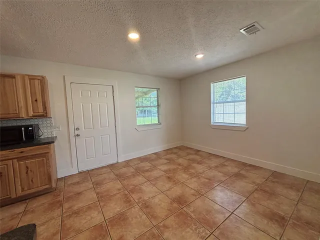 an empty room with windows and fan