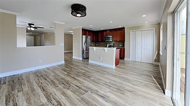 a view of kitchen with stainless steel appliances kitchen island granite countertop a refrigerator and a stove