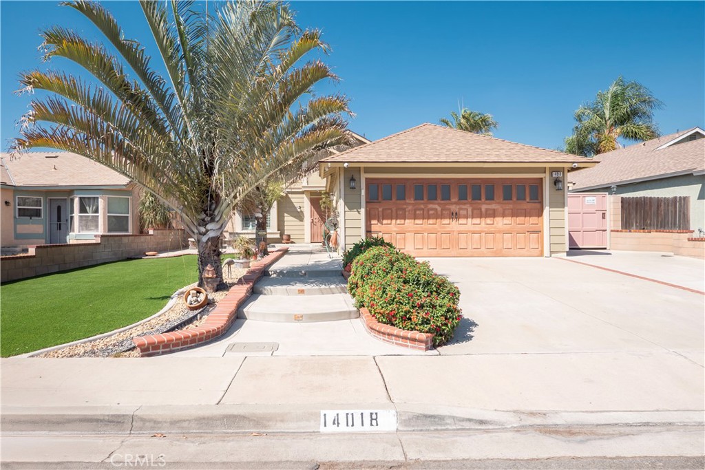 a front view of a house with a yard and potted plants
