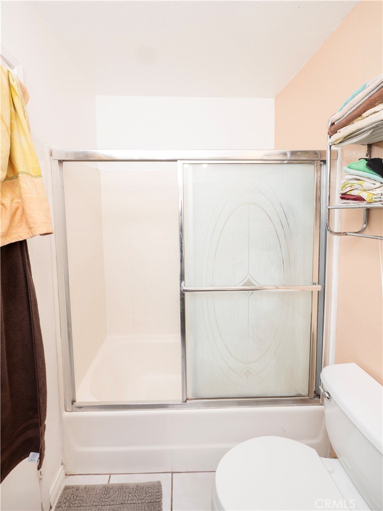 14018 Ridgewood Drive Fontana, CA 92337 - Photo 12 of 30 a bathroom with a shower curtain and a toilet