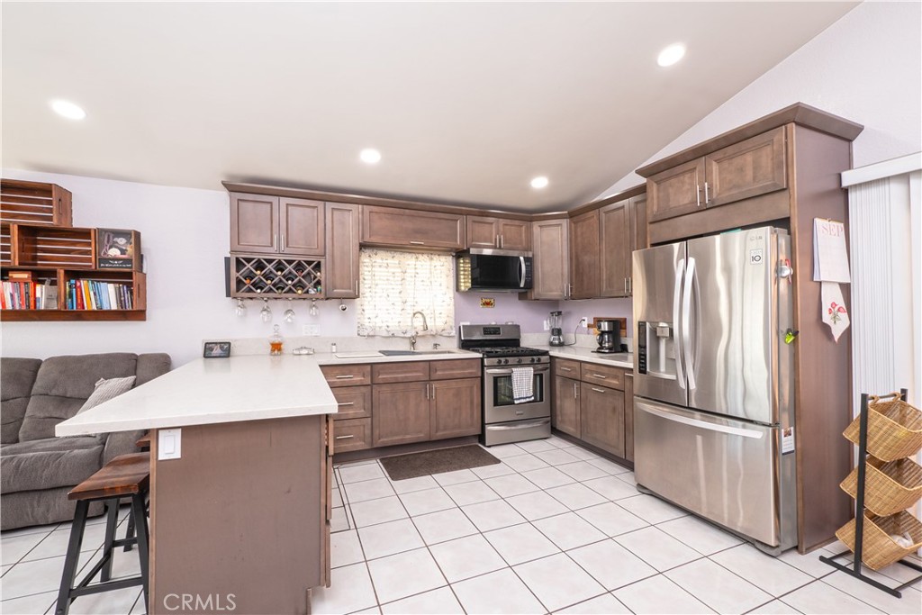 14018 Ridgewood Drive Fontana, CA 92337 - Photo 7 of 30 a kitchen with a refrigerator a sink and a stove top oven