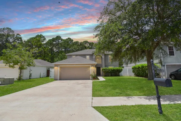 a front view of a house with a yard and garage