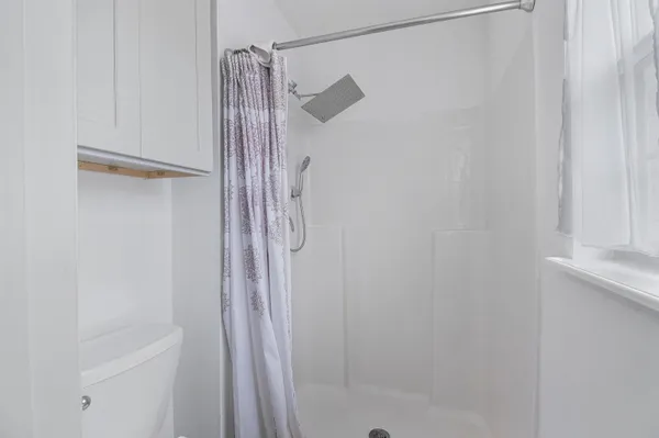 a bathroom with a shower and a glass door