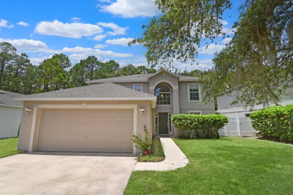 a front view of a house with a yard and garage