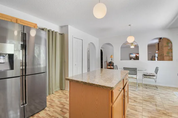 a kitchen with stainless steel appliances granite countertop a refrigerator a stove and a sink