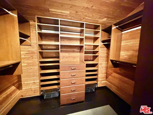 a view of walk in closet and empty room