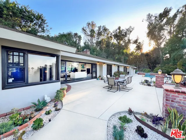 a view of a patio with table and chairs potted plants with wooden floor and fence