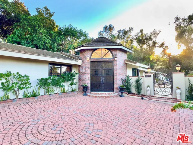 a front view of a house with a yard and potted plants