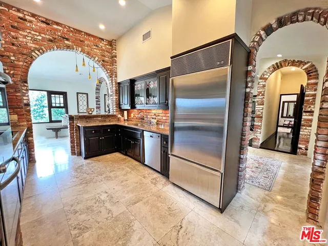 a kitchen with stainless steel appliances granite countertop a refrigerator a stove and a sink