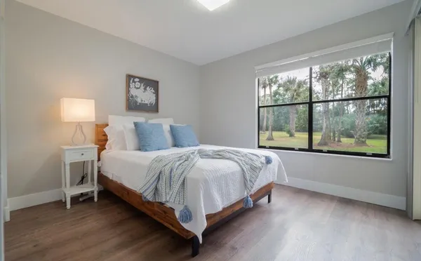a bed sitting in a bedroom next to a window