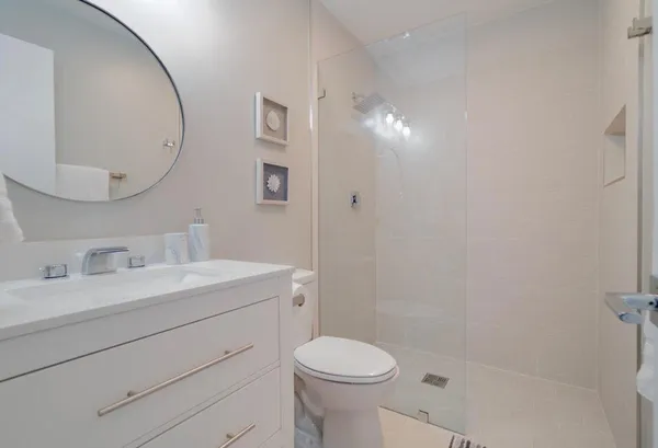 a bathroom with a sink a toilet and a mirror