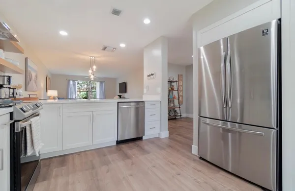 a kitchen with white cabinets and stainless steel appliances
