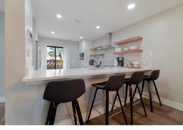 a kitchen with a table chairs a sink and cabinets