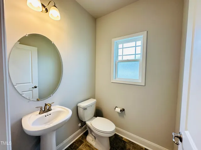 a bathroom with a sink mirror and toilet