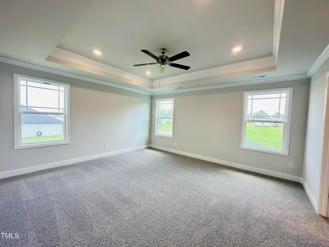 an empty room with windows and ceiling fan