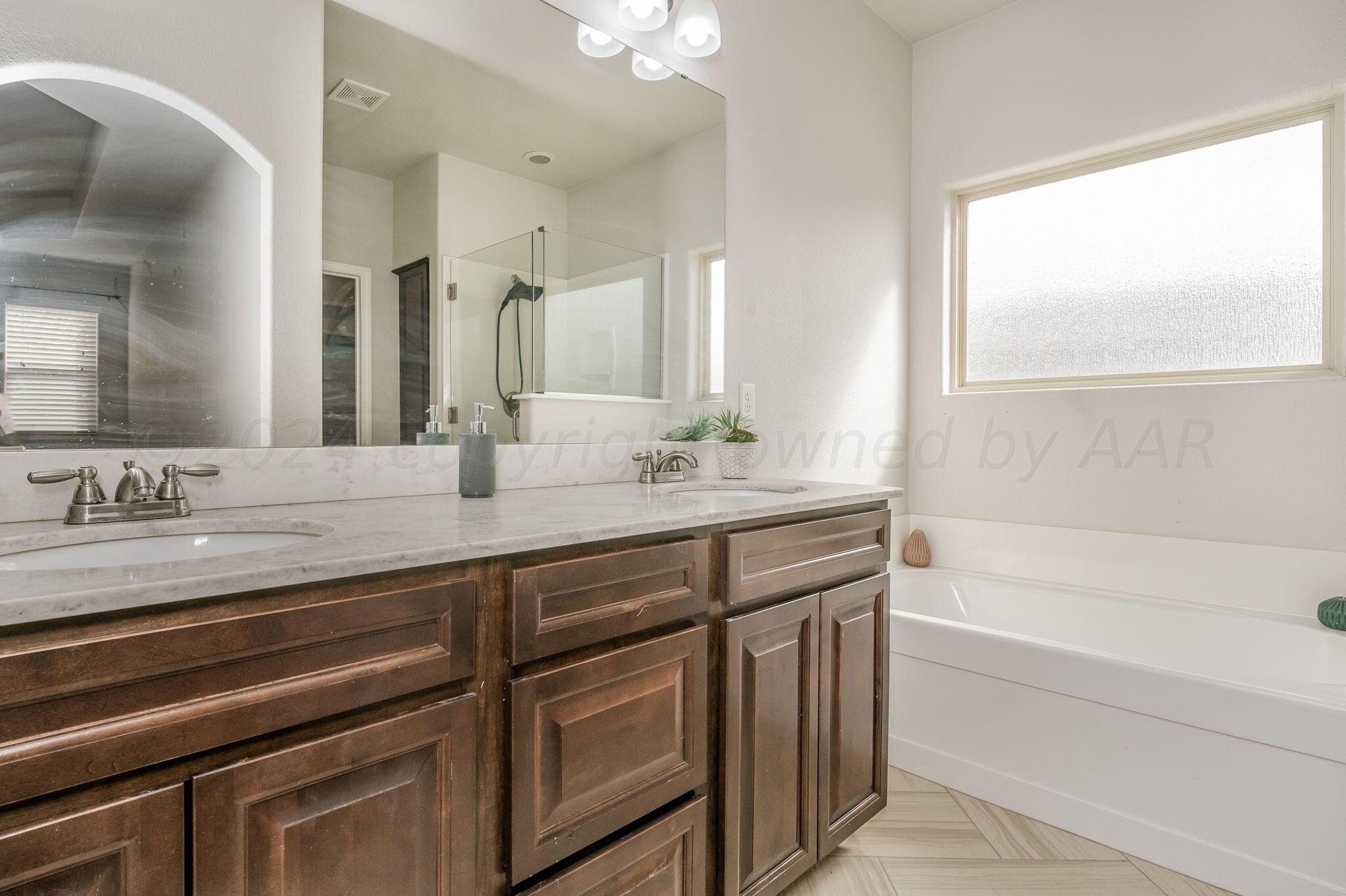 1201 Cabernet Way Amarillo, TX 79124 - Photo 15 of 18 a bathroom with a double vanity sink and a bathtub