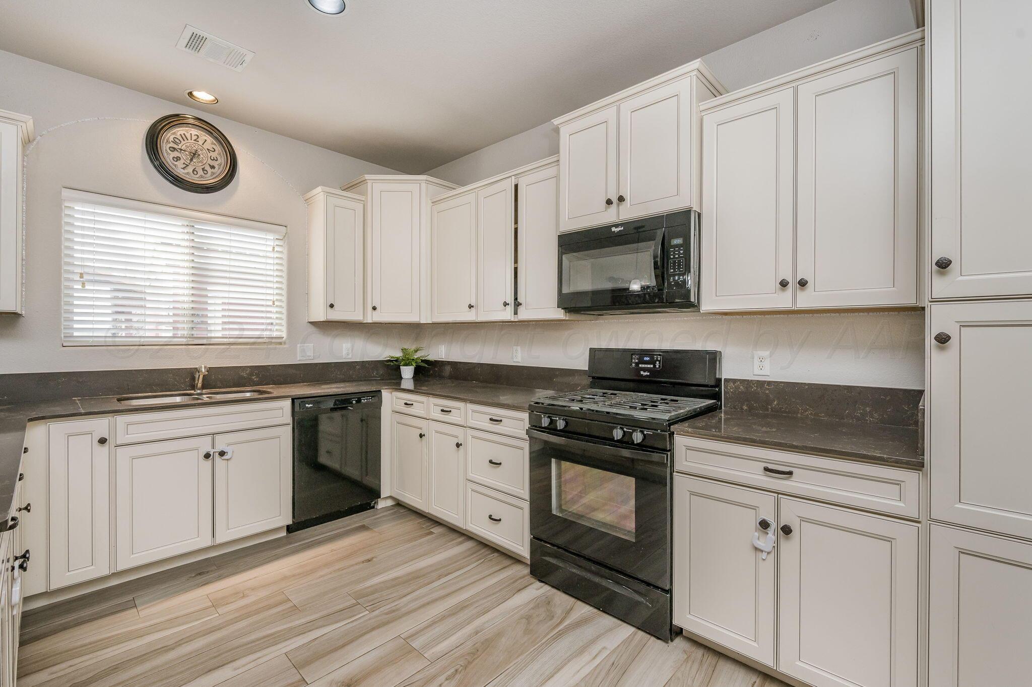 1201 Cabernet Way Amarillo, TX 79124 - Photo 5 of 18 a kitchen with granite countertop white cabinets white stainless steel appliances and a sink
