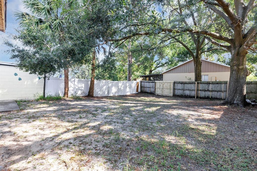 3701 Spring Land Drive Orlando, FL 32818 - Photo 21 of 21 a view of a yard with a large tree and wooden fence