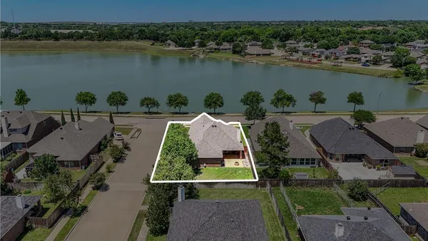 an aerial view of a house with outdoor space and lake view