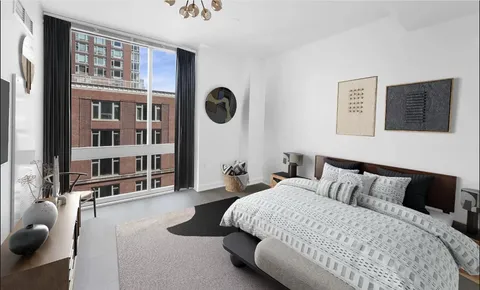 a bedroom with a bed and a large window