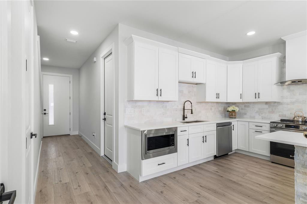 2608 West St Joseph Street, Unit 2 Tampa, FL 33607 - Photo 15 of 29 a kitchen with cabinets stainless steel appliances a sink and wooden floor