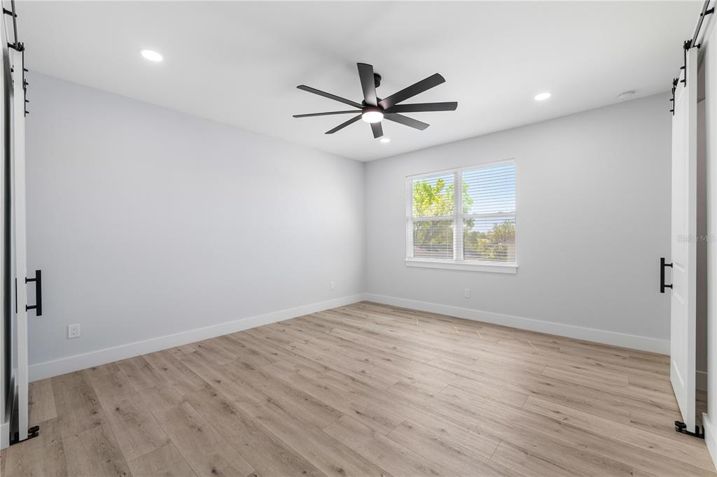 2608 West St Joseph Street, Unit 2 Tampa, FL 33607 - Photo 8 of 29 an empty room with wooden floor ceiling fan and windows