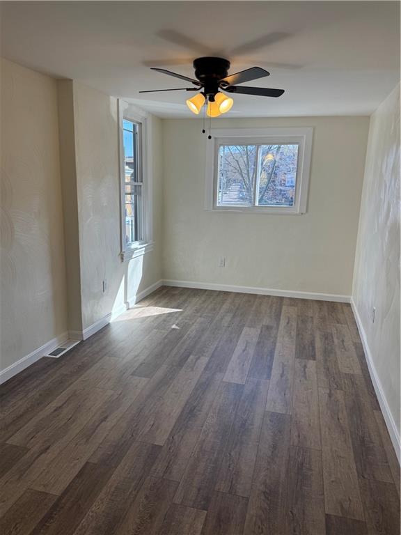 5423 Wellesley Avenue Pittsburgh, PA 15206 - Photo 17 of 27 an empty room with wooden floor a ceiling fan and windows