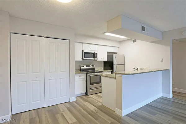 a kitchen with stainless steel appliances a refrigerator and a stove top oven