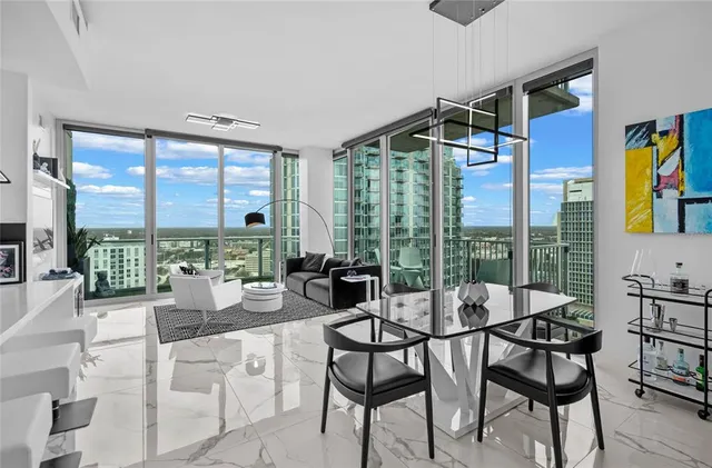 a dining room with furniture and large windows