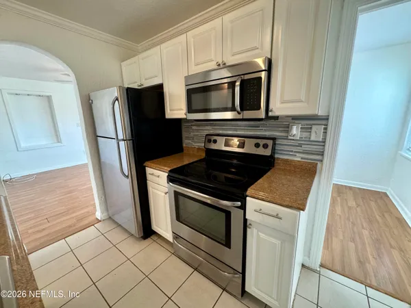a kitchen with white cabinets and stainless steel appliances