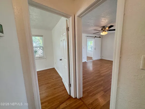 a view of a hallway with wooden floor and staircase