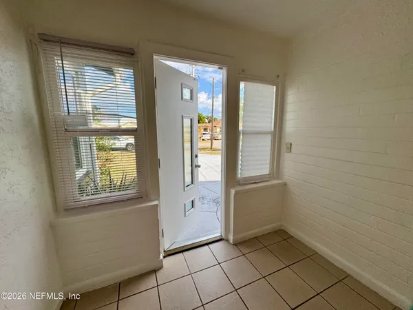 a view of an empty room with window and cabinet