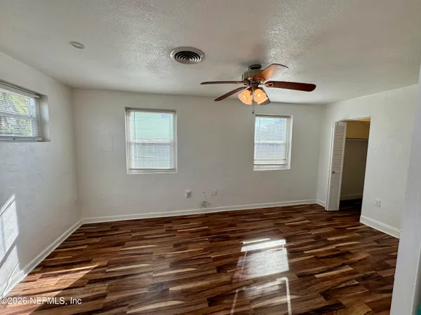 a view of room with window ceiling fan and hardwood floor